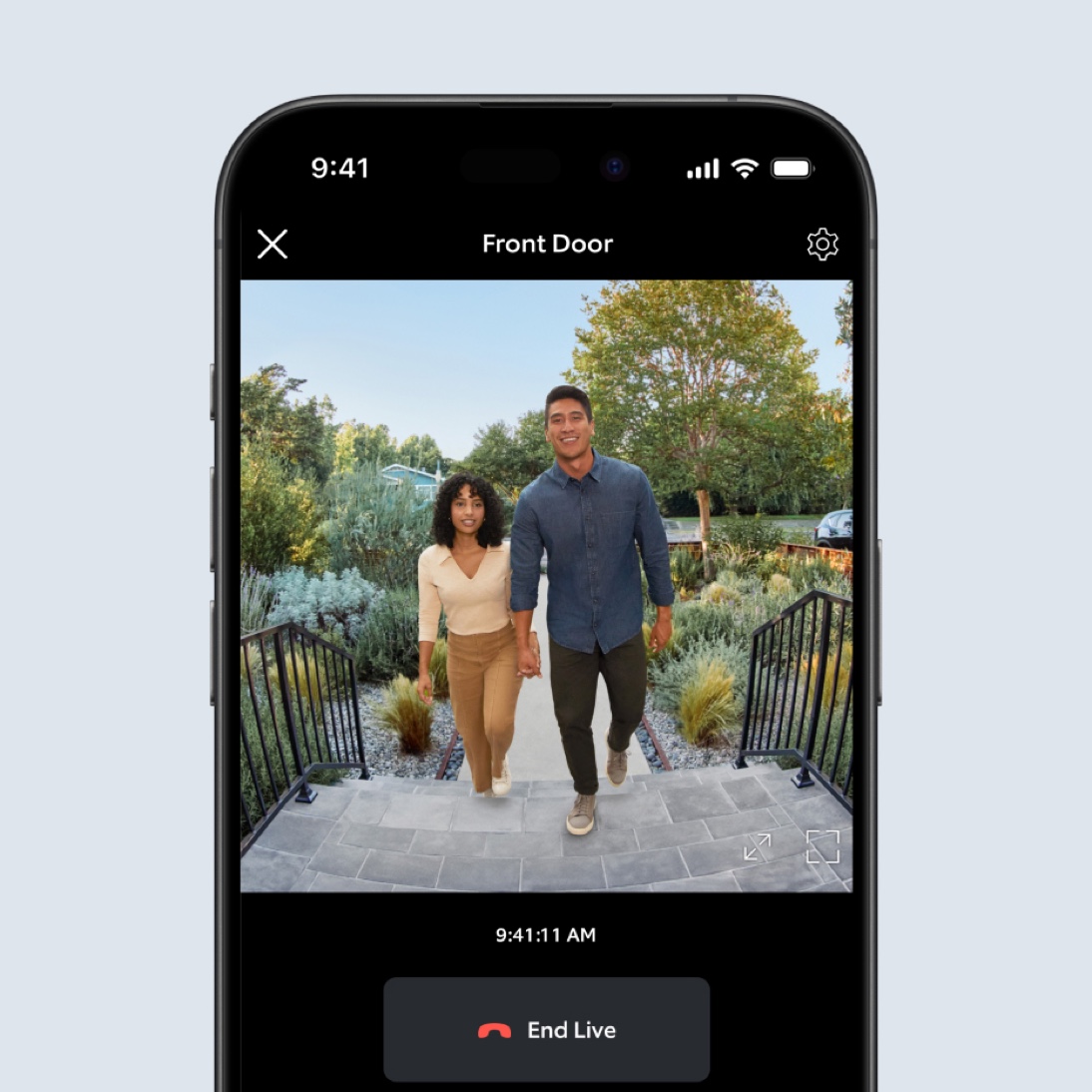 A phone screen shows video footage in the Ring App of a man and woman walking up a staircase toward the camera.